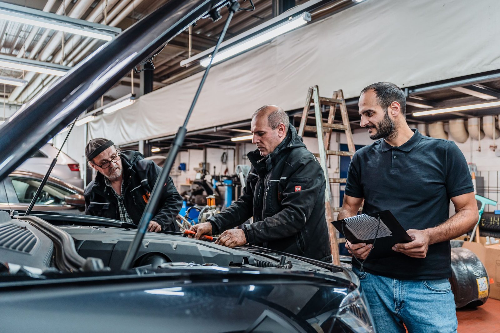 Mechanikerteam von Kayki Autoservice überprüft den Motor eines Fahrzeugs in der Werkstatt in Hildesheim